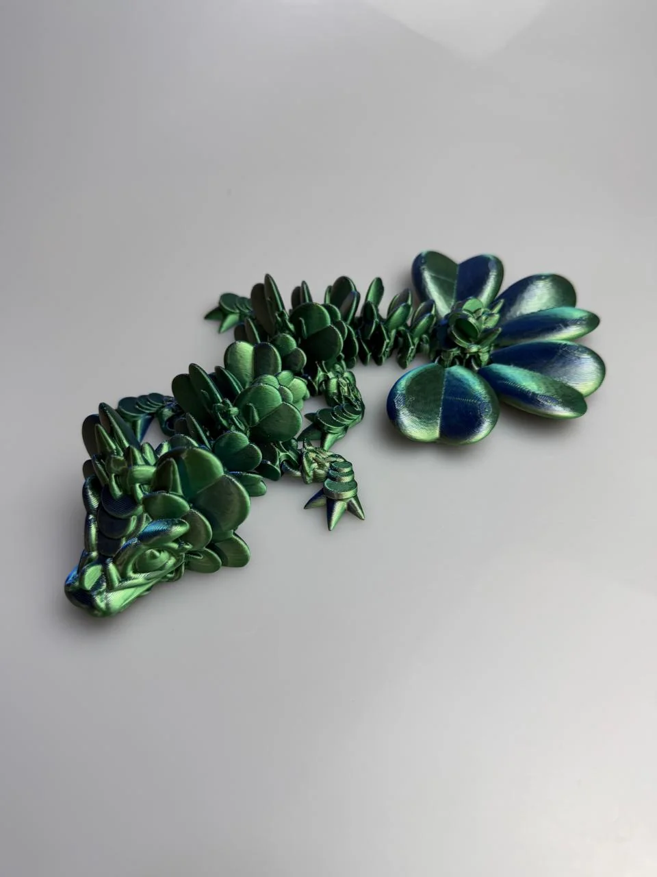 Baby Lucky Clover Dragon: emerald green and teal dragon figurine, overlapping rounded scale-like segments along body