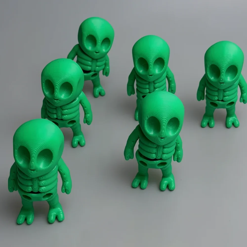 Tiny Alien Skeleton: green and black six identical small alien figurines, large bulbous oval head