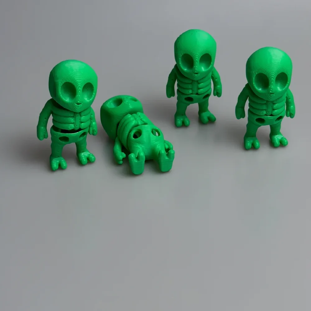 Tiny Alien Skeleton: green and black alien figurine, large bulbous head