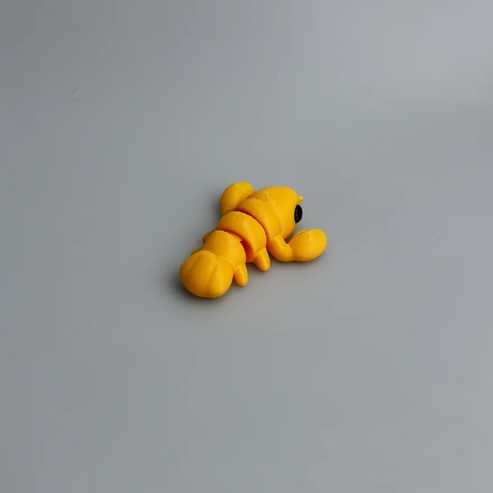 Baby Lobster: yellow and black segmented caterpillar figurine, rounded head with small black circular eye dot