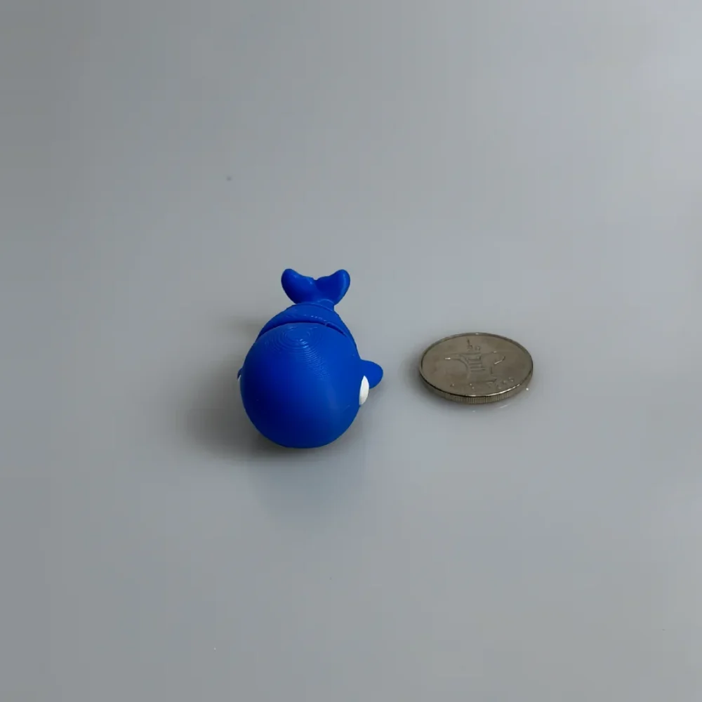 Baby Blue Whale: blue and white whale figurine, concentric circular layer lines on top of back