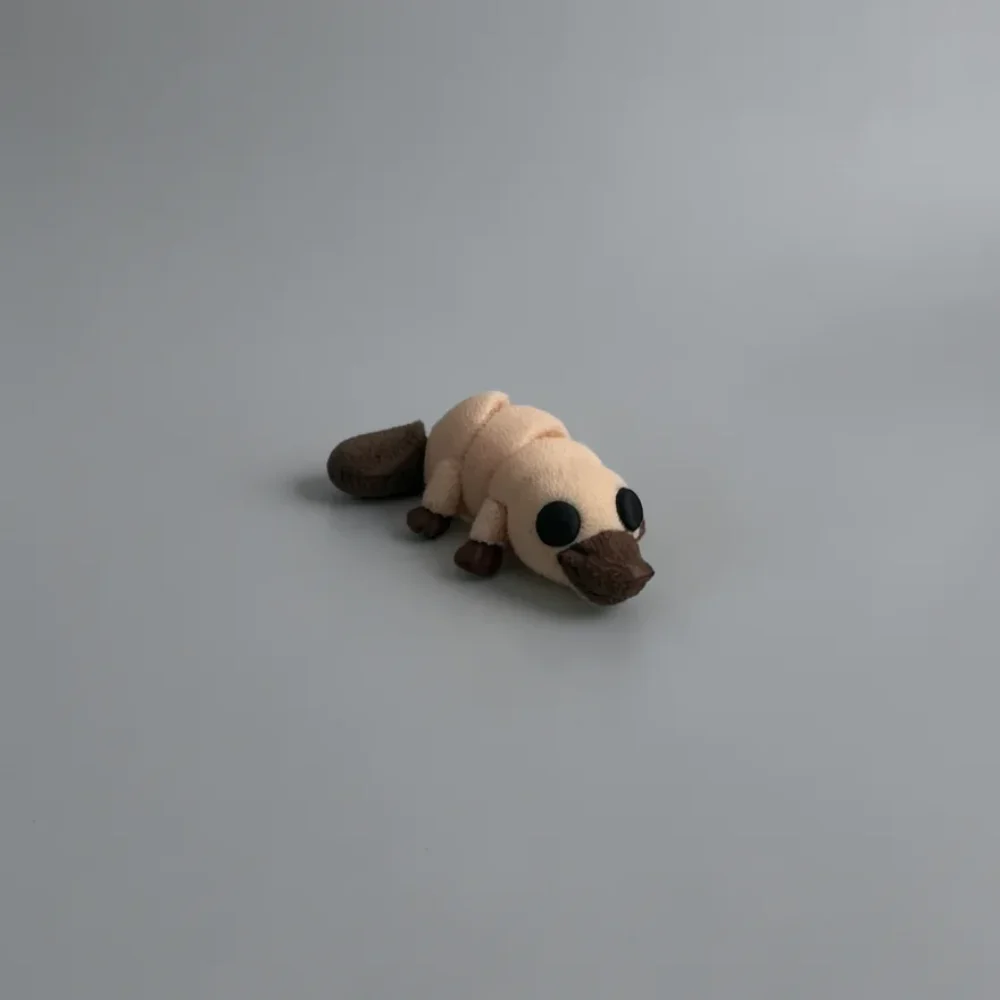 Baby Platypus: pale beige and dark brown platypus figurine, flat paddle-shaped tail