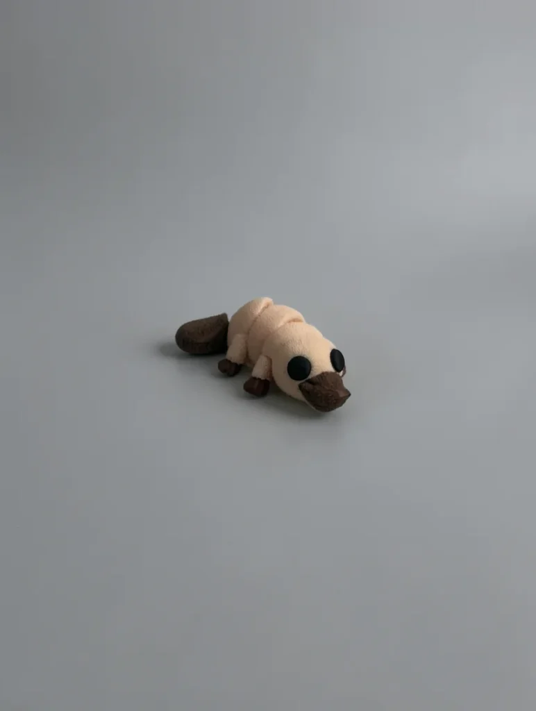 Baby Platypus: pale beige and dark brown platypus figurine, flat paddle-shaped tail