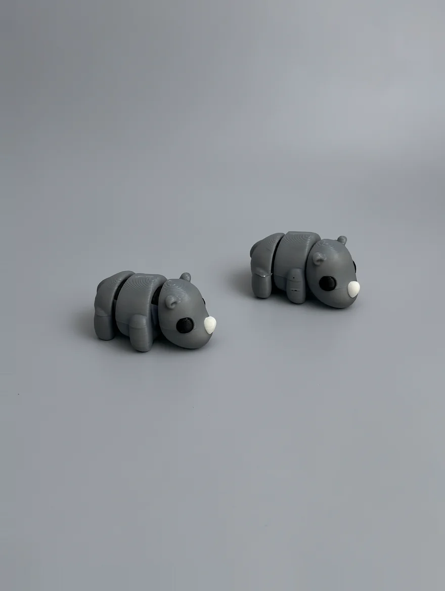 Baby Rhino: grey and black articulated segmented animal figurines (two pieces, appearing to be bears or similar animals)