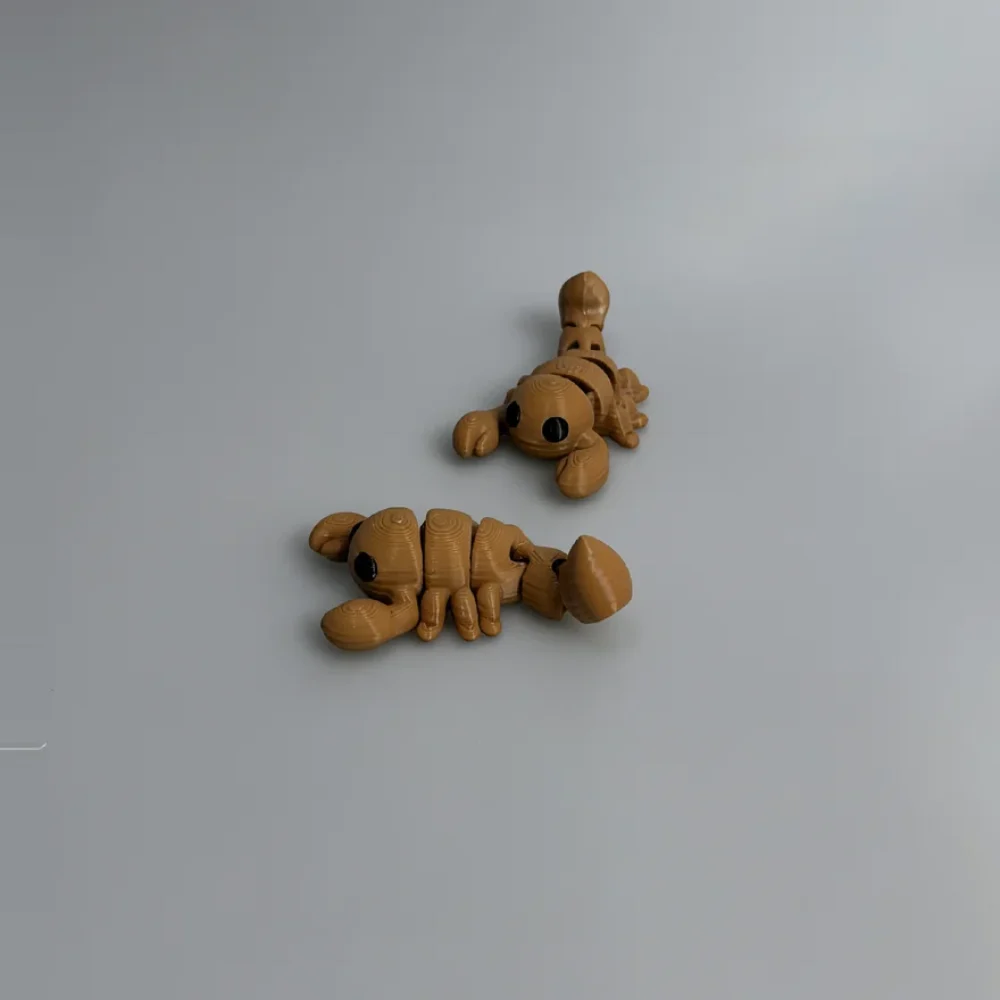 Baby Scorpion: tan and black Two scorpion-like insect figurines, each a single continuous articulated/segmented piece