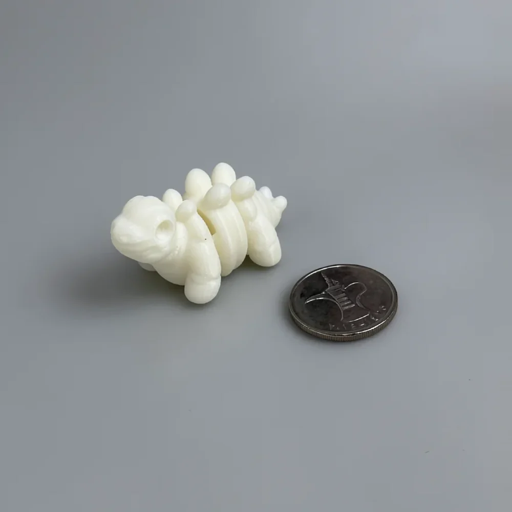 Baby Stegosaurus Skeleton: white articulated segmented creature figurine (flexi-style caterpillar/worm), rounded snout
