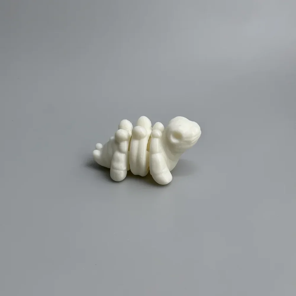 Baby Stegosaurus Skeleton: creamy off-white segmented animal figurine (turtle or caterpillar design)