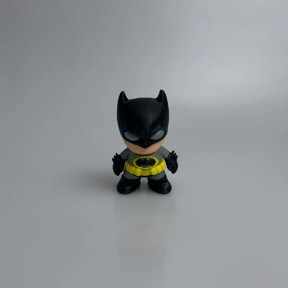 Batman: black and grey Batman figurine (chibi/Q-version style), black cowl with pointed ears and horizontal 3D-print ridges