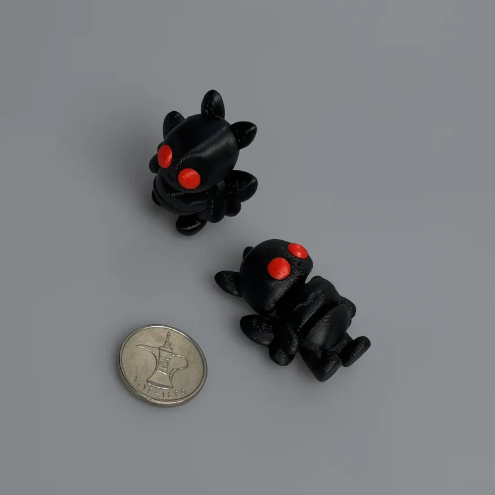 Tiny Mothman: black and red two identical small stylized creature figurines (bear/bat/demon mix), round head