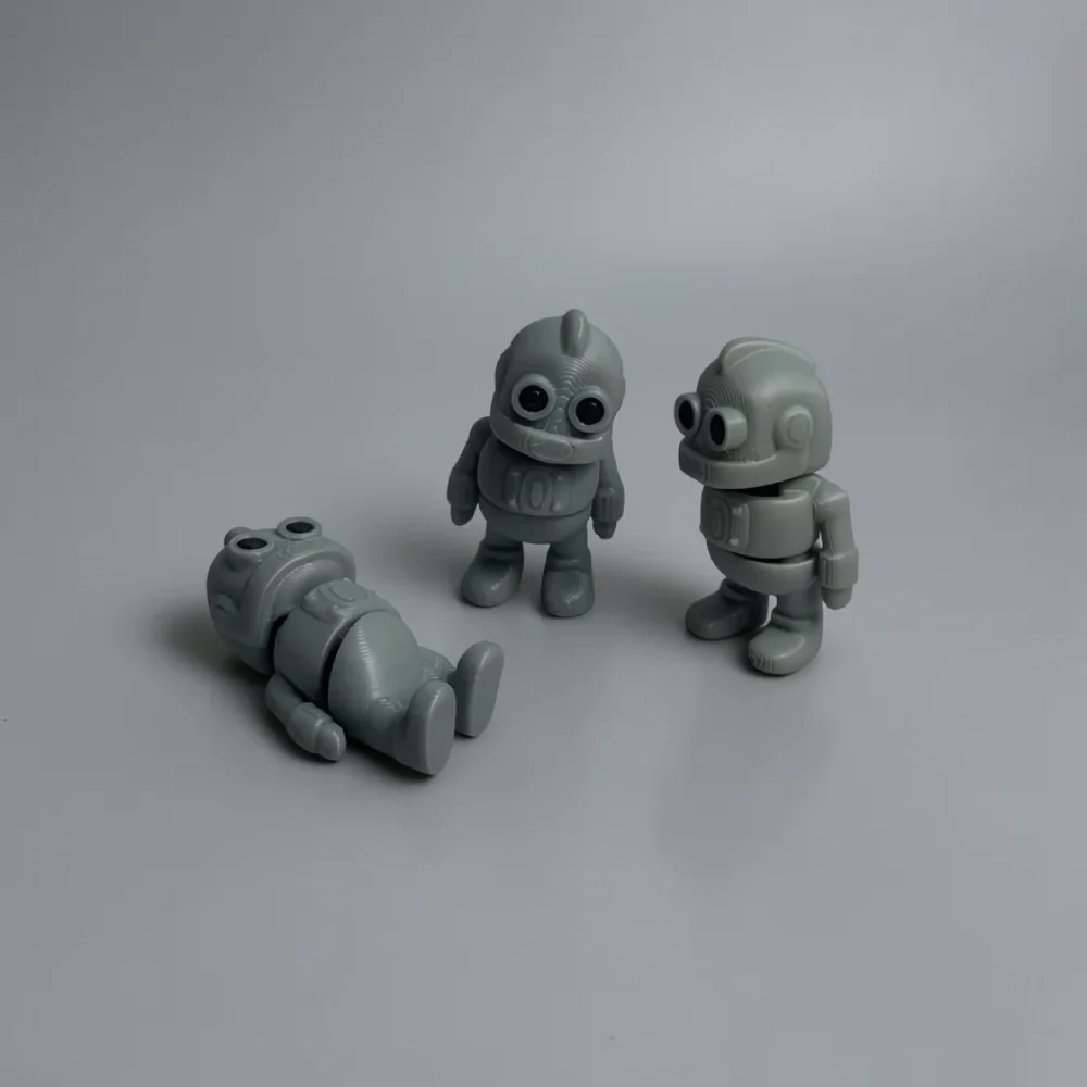 Tiny Robot: grey and black retro-style robot figurines (three-piece set), two circular protrusions on head (left figure)