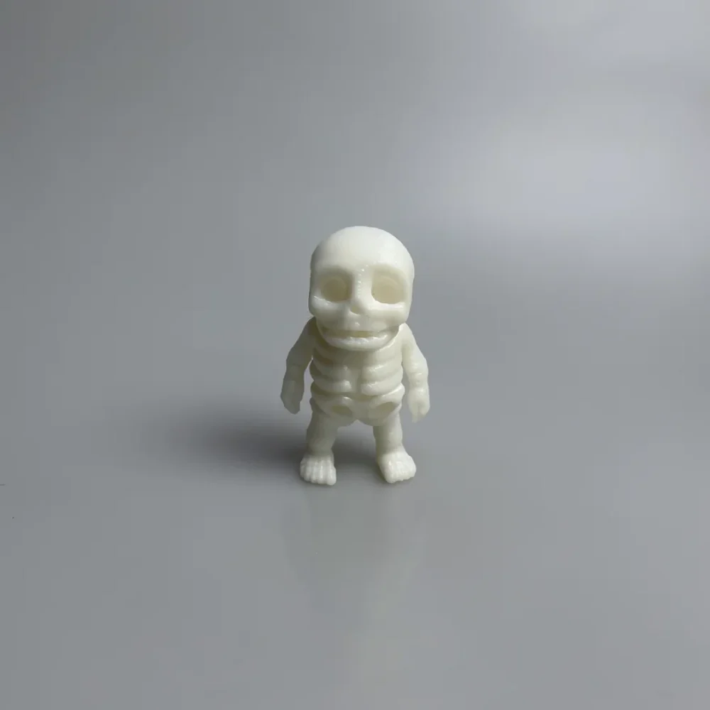 Tiny Skeleton: white chibi skeleton figurine, large rounded skull with deep hollow eye sockets