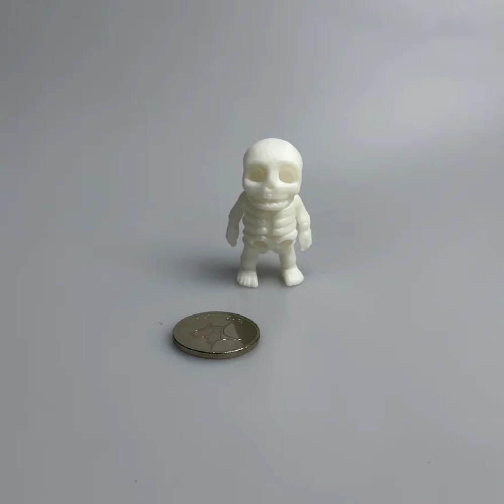 Tiny Skeleton: off-white and cream chibi-style baby skeleton figurine, proportionally large rounded skull