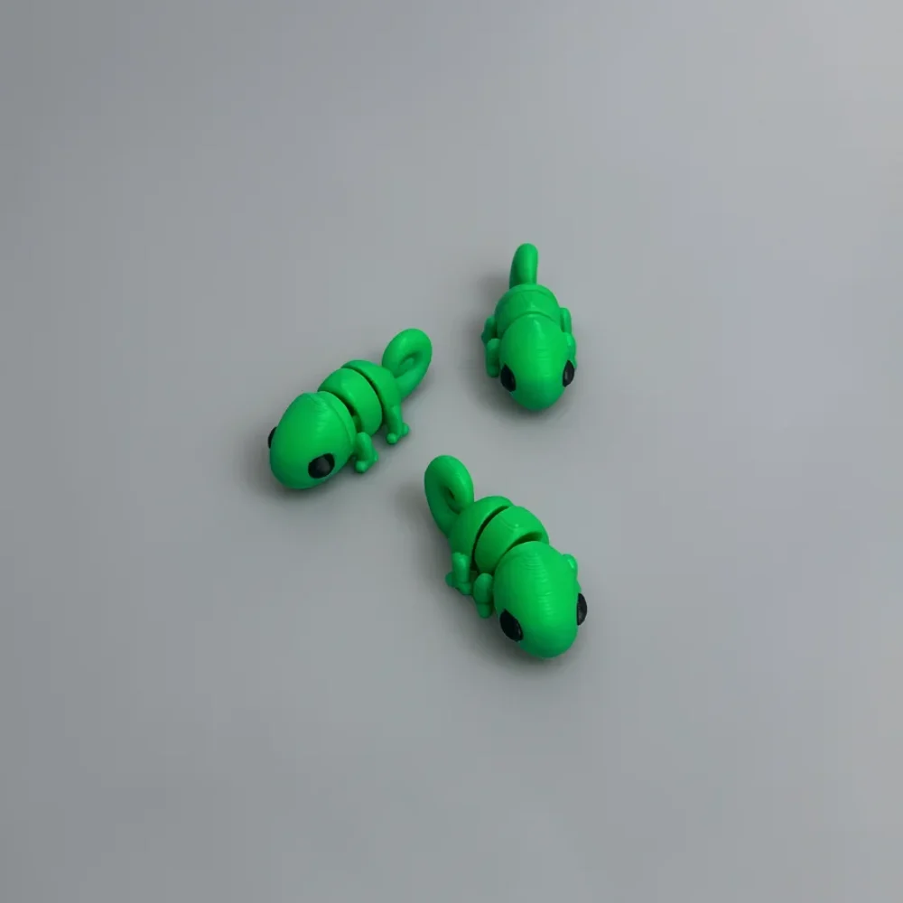 Baby Chameleon: green and black Three small lizard or chameleon figurines with a segmented, block-like body design