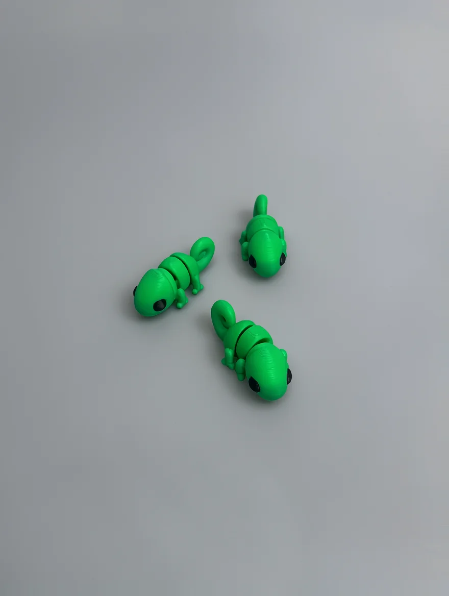 Baby Chameleon: green and black Three small lizard or chameleon figurines with a segmented, block-like body design