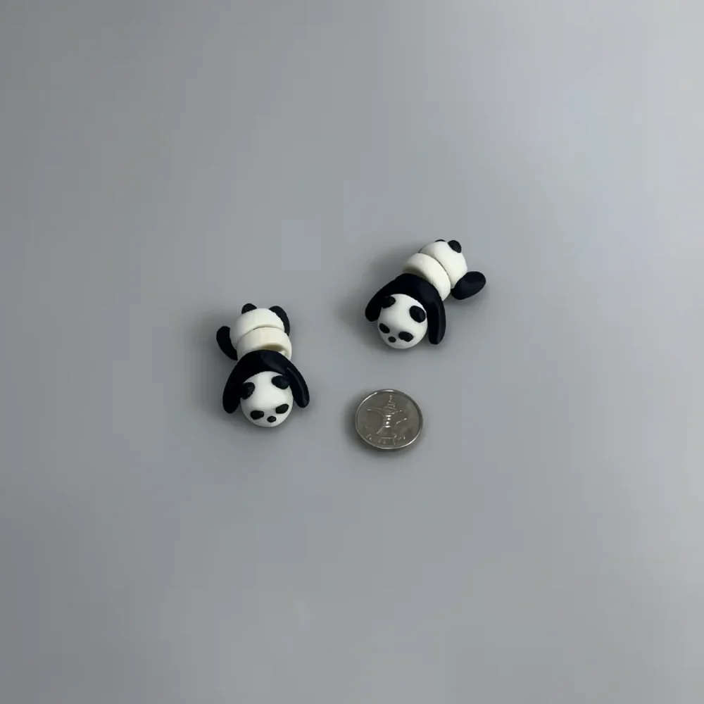 Baby Panda: white and black two small segmented panda figurines, segmented body resembling stacked beads or rolled segments