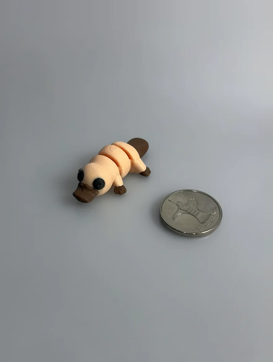 Baby Platypus: pale peach and dark brown articulated platypus figurine, segmented body with visible joint rings