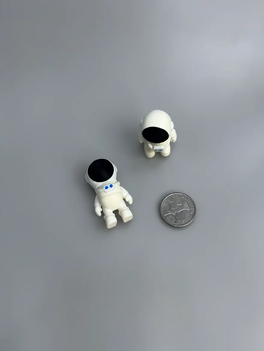 Tiny Astronaut: white and black two miniature astronaut figurines (separate pieces), black circular helmet visors