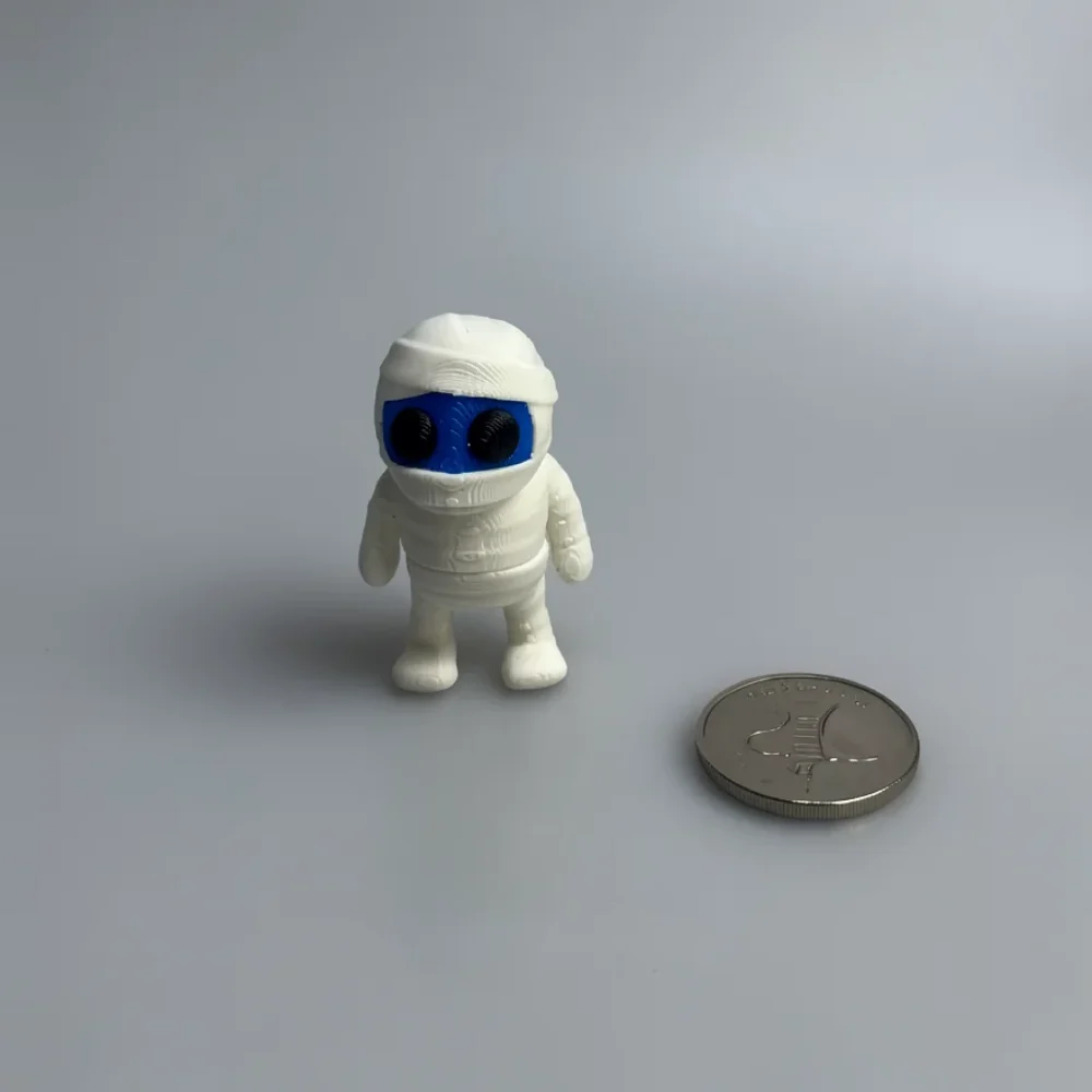 Tiny Mummy: white and blue small character figurine resembling a mummy or astronaut in a bulky suit