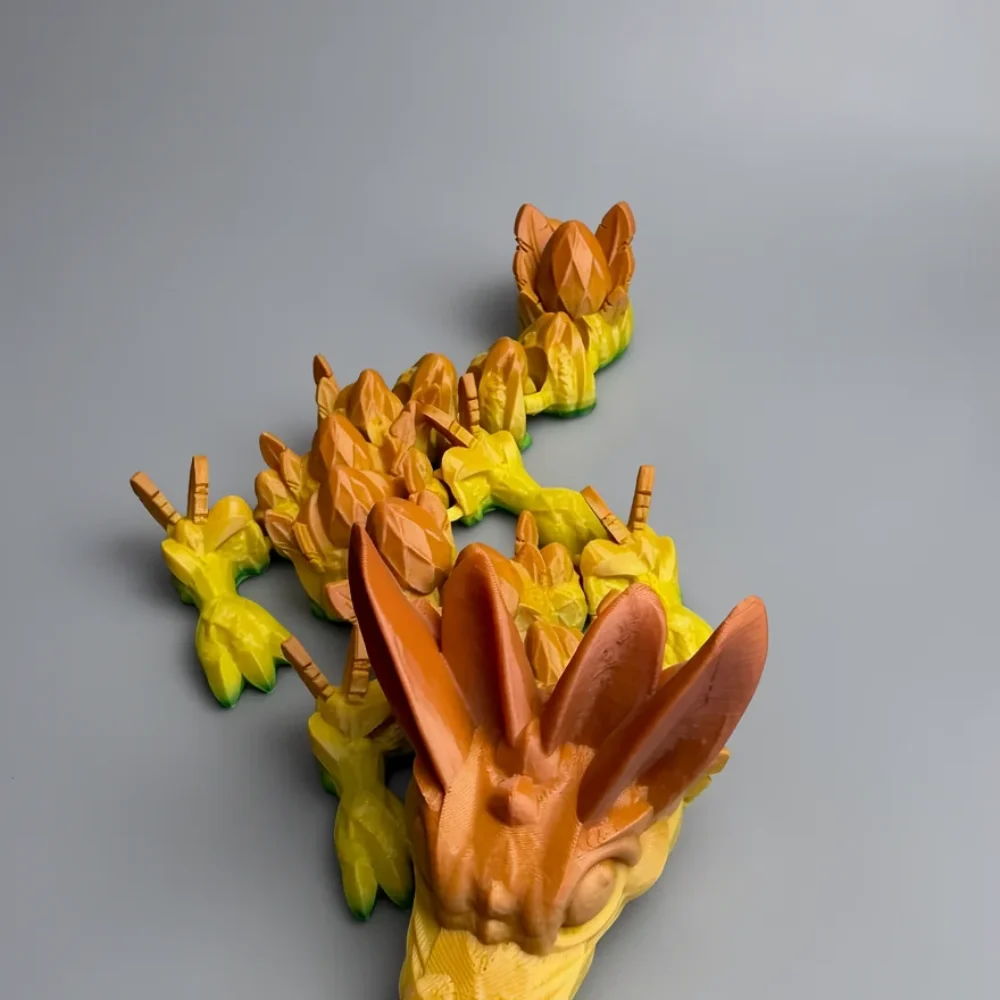 Baby Easter Dragon: yellow and orange-brown segmented dragon figurine, large faceted ear-like horns