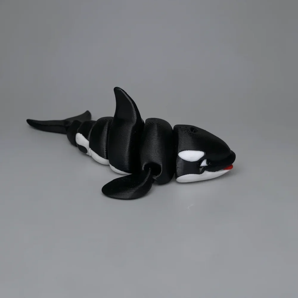 Orca: black and white articulated orca (killer whale) figurine, articulated segmented body with visible joint gaps