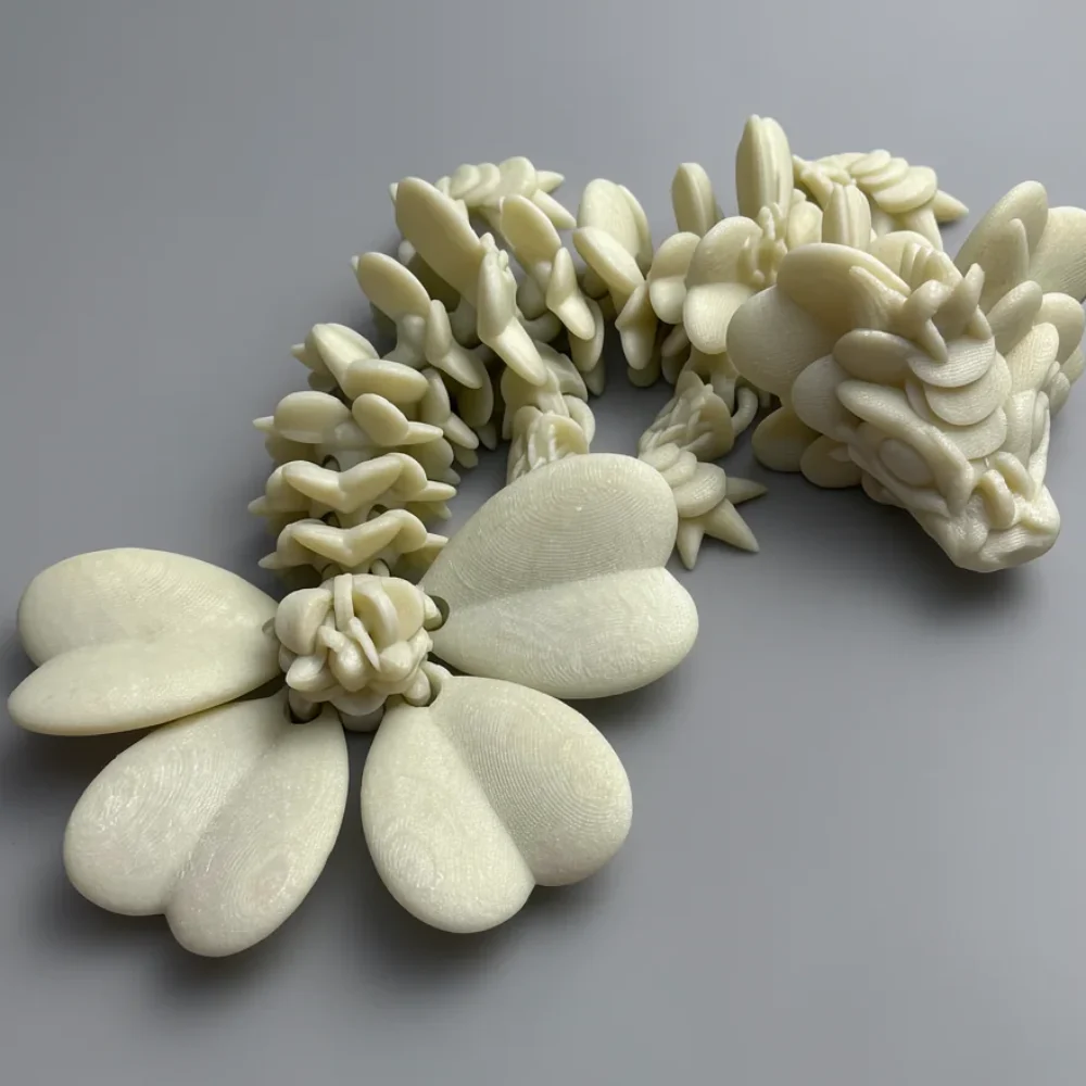 Baby Lucky Clover Dragon: cream (off-white/ivory) printed floral piece - a four-petal flower with a curving leafy/scale…