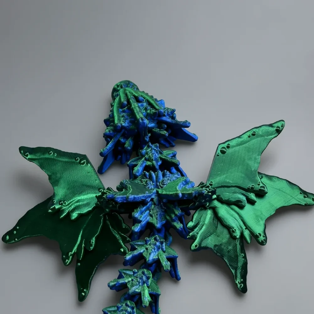 Baby Ocean Serpent Dragon: blue and green segmented dragon figurine with bat-like wings, segmented thorny spine