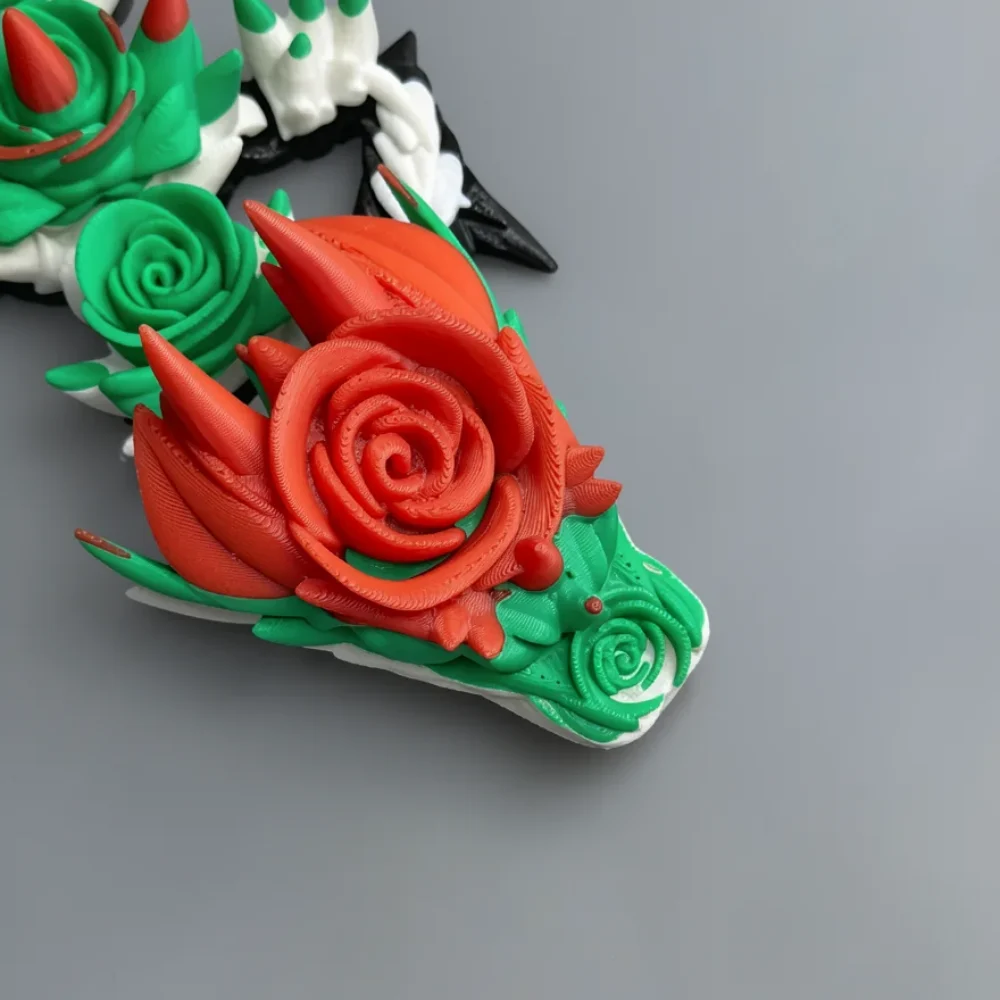 Baby Rose Dragon: red and green 3D-printed decorative piece featuring roses and thorns mounted on a white irregular base