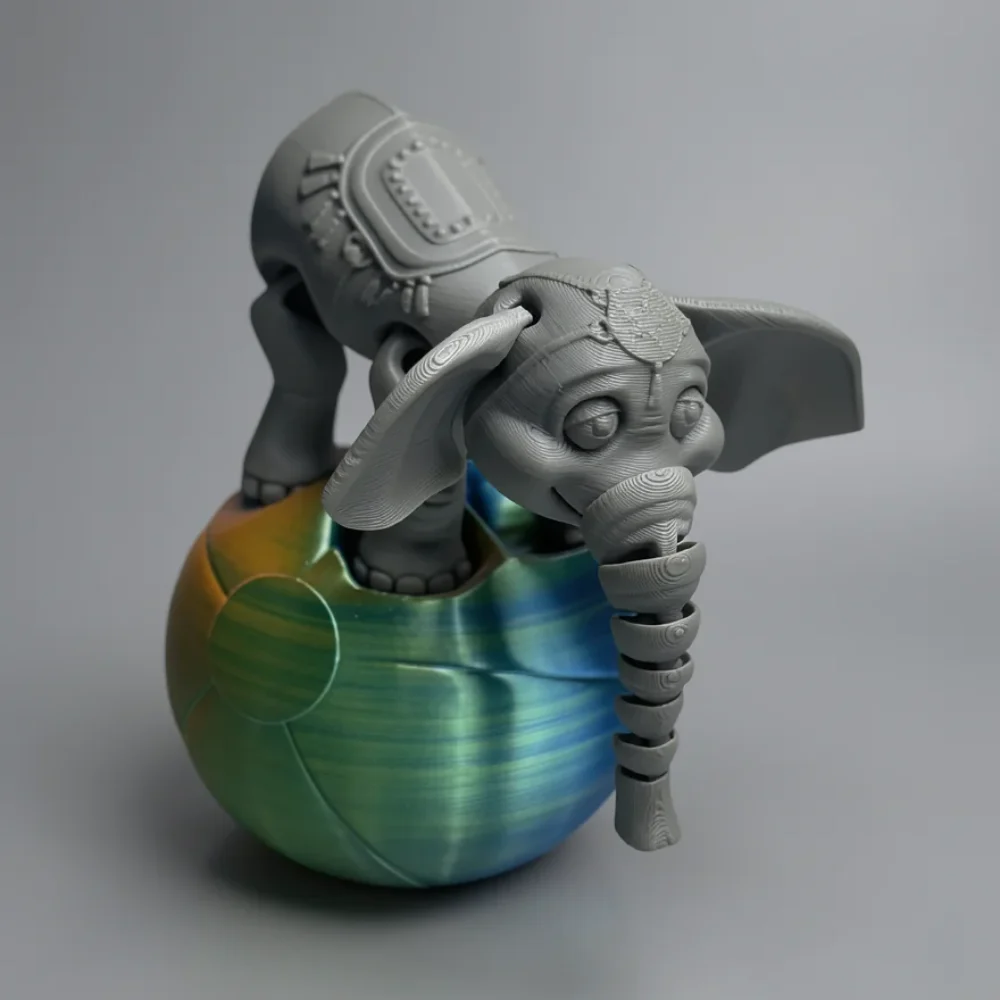 Circus Elephant Set: grey and green elephant figurine emerging from a colorful egg, segmented ring-like trunk