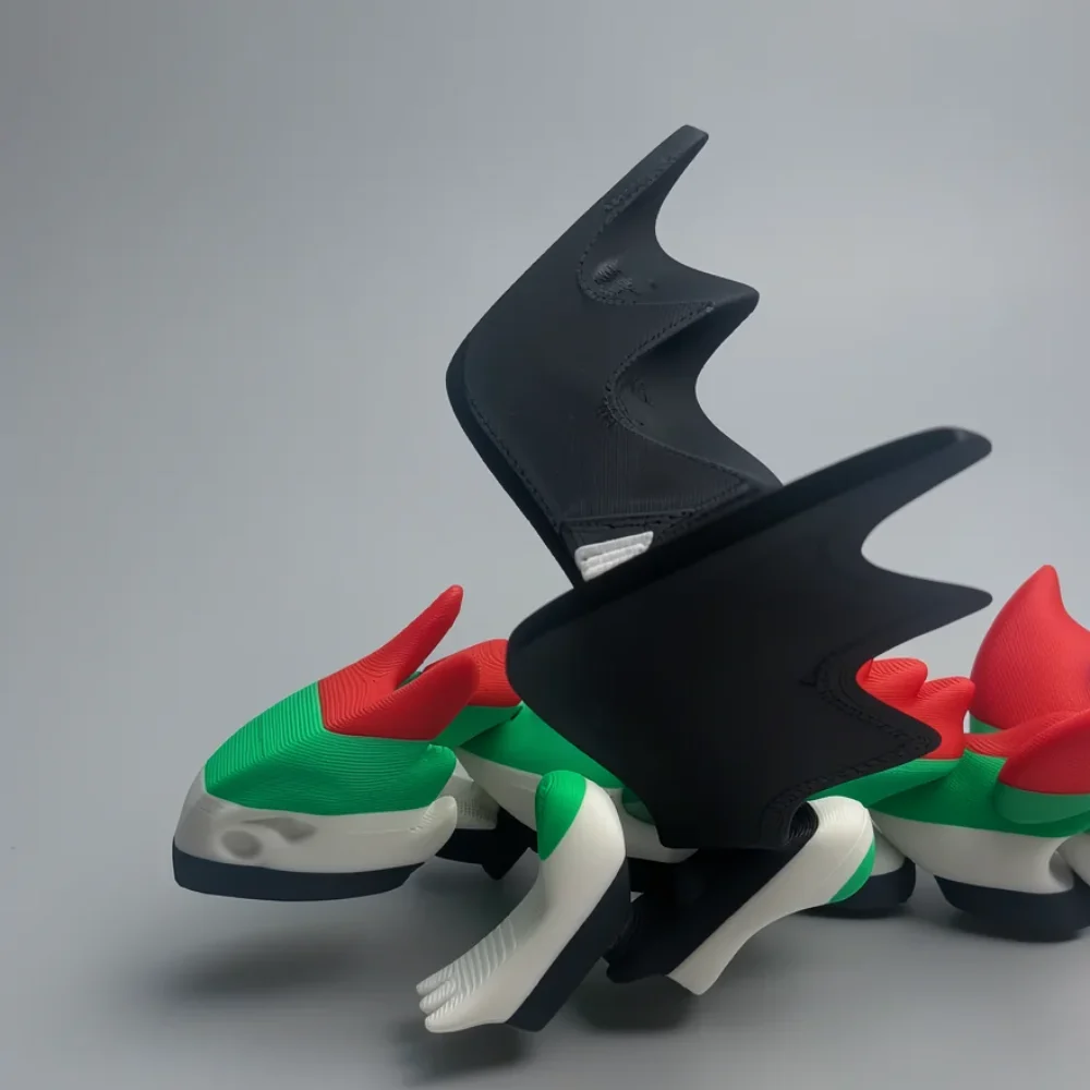Flapping UAE Dragon: green and black 3D-printed dragon figurine, curved red horns
