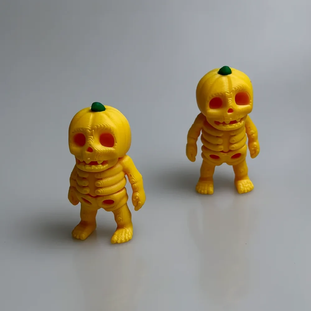 Tiny Pumpkin Skeleton: yellow-orange and dark green pumpkin-skeleton figurine (two matching pieces, differing in size)