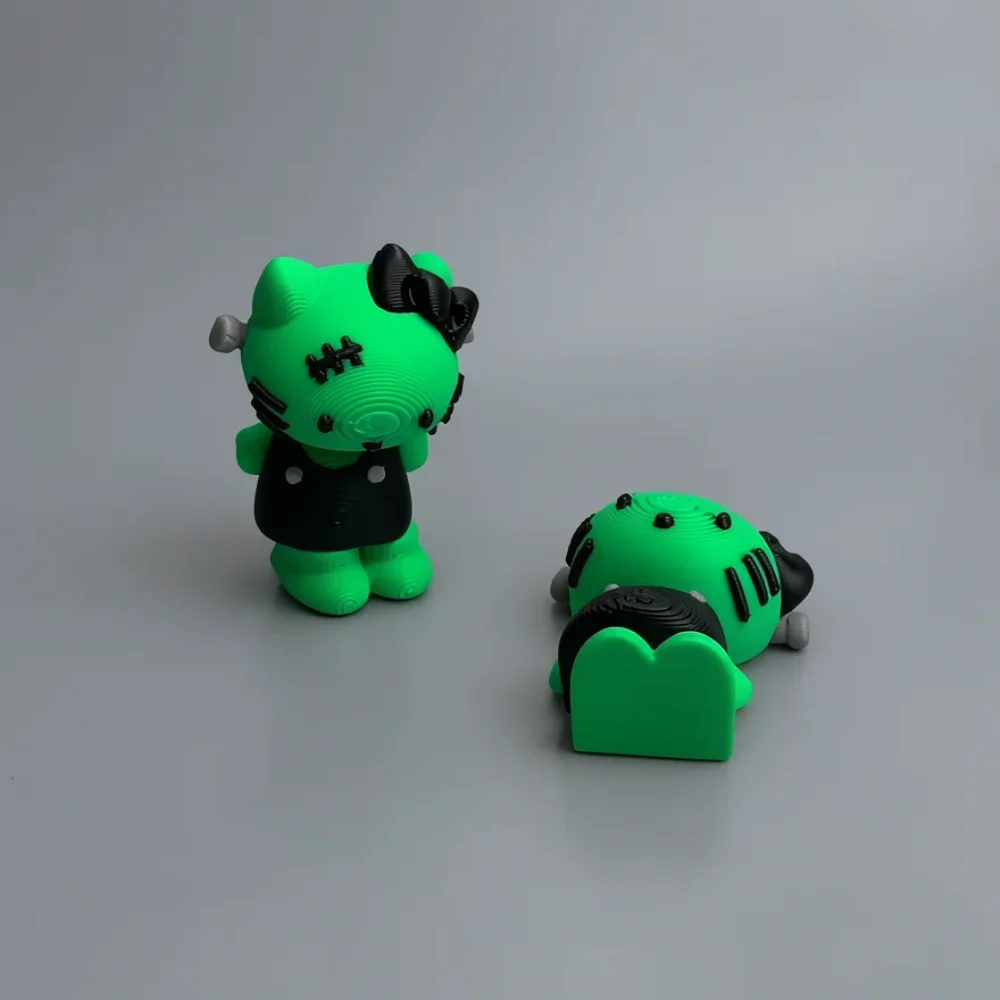 Frankenstein Hello Kitty: neon green and black two Hello Kitty Frankenstein mashup figurines (one standing upright, one…