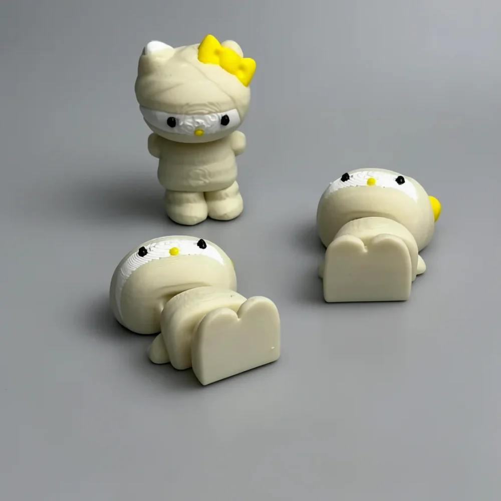 Mummy Hello Kitty: off-white and yellow Hello Kitty figurine (mummy/bandage theme), yellow bow on left ear