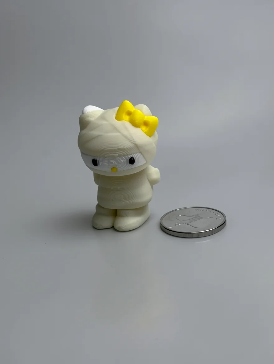 Mummy Hello Kitty: cream and yellow Hello Kitty mummy figurine, yellow bow on left ear