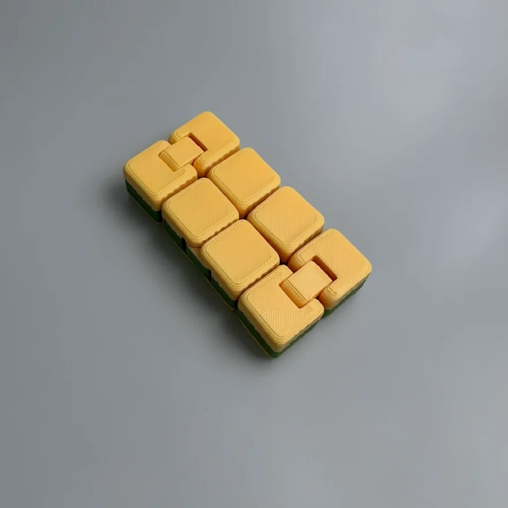 Infinity Cube: cream-yellow and dark green interlocking block puzzle (cluster of rectangular blocks with tabs and slots)