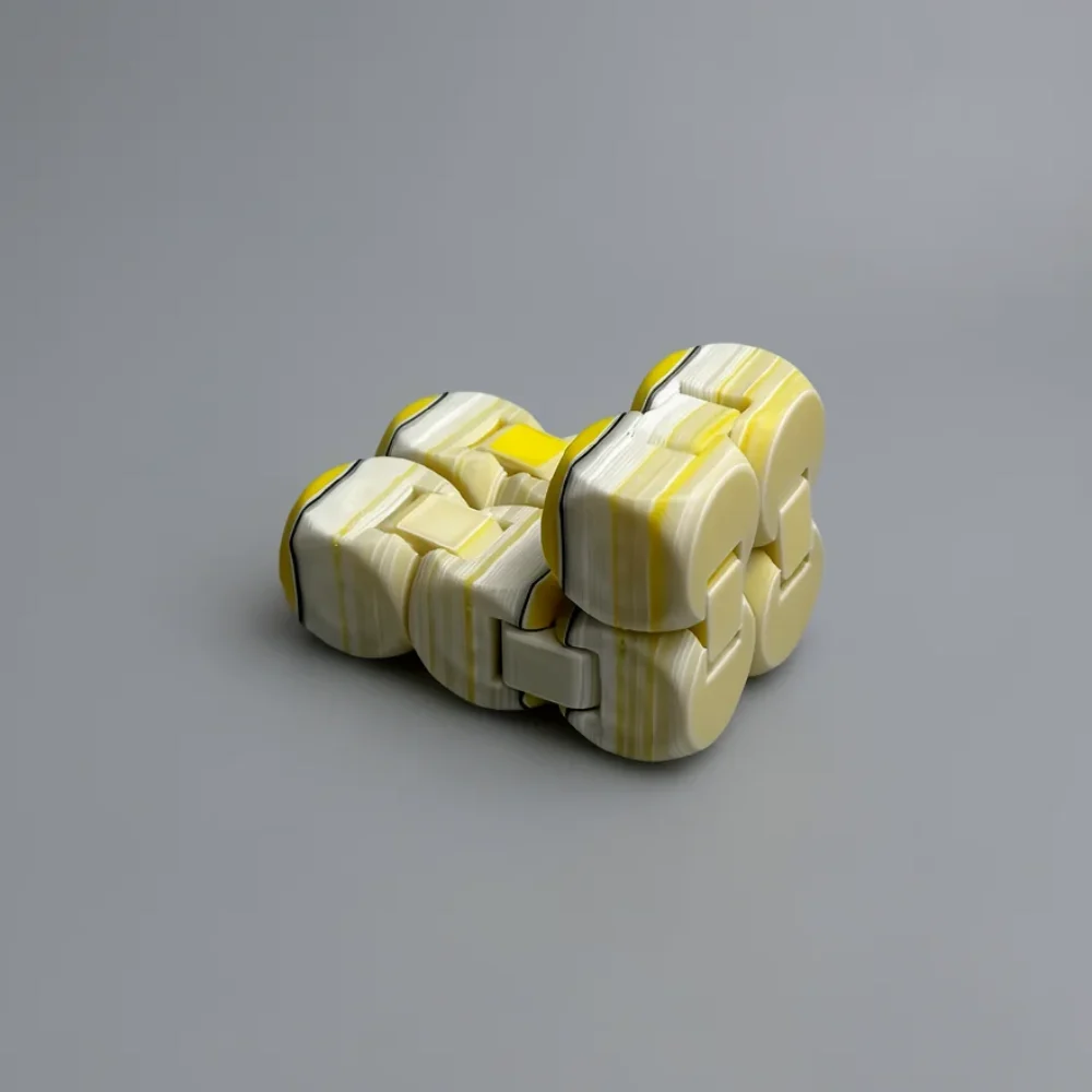 Infinity Cube: cream / off-white and yellow segmented interlocking 3D-printed toy